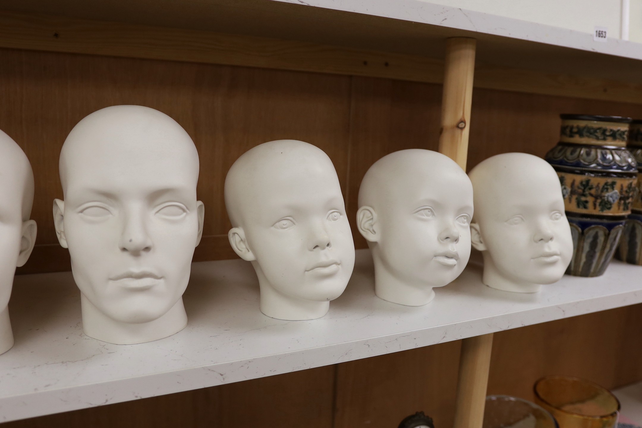 A set of seven fibreglass mannequin heads, largest 23cms high